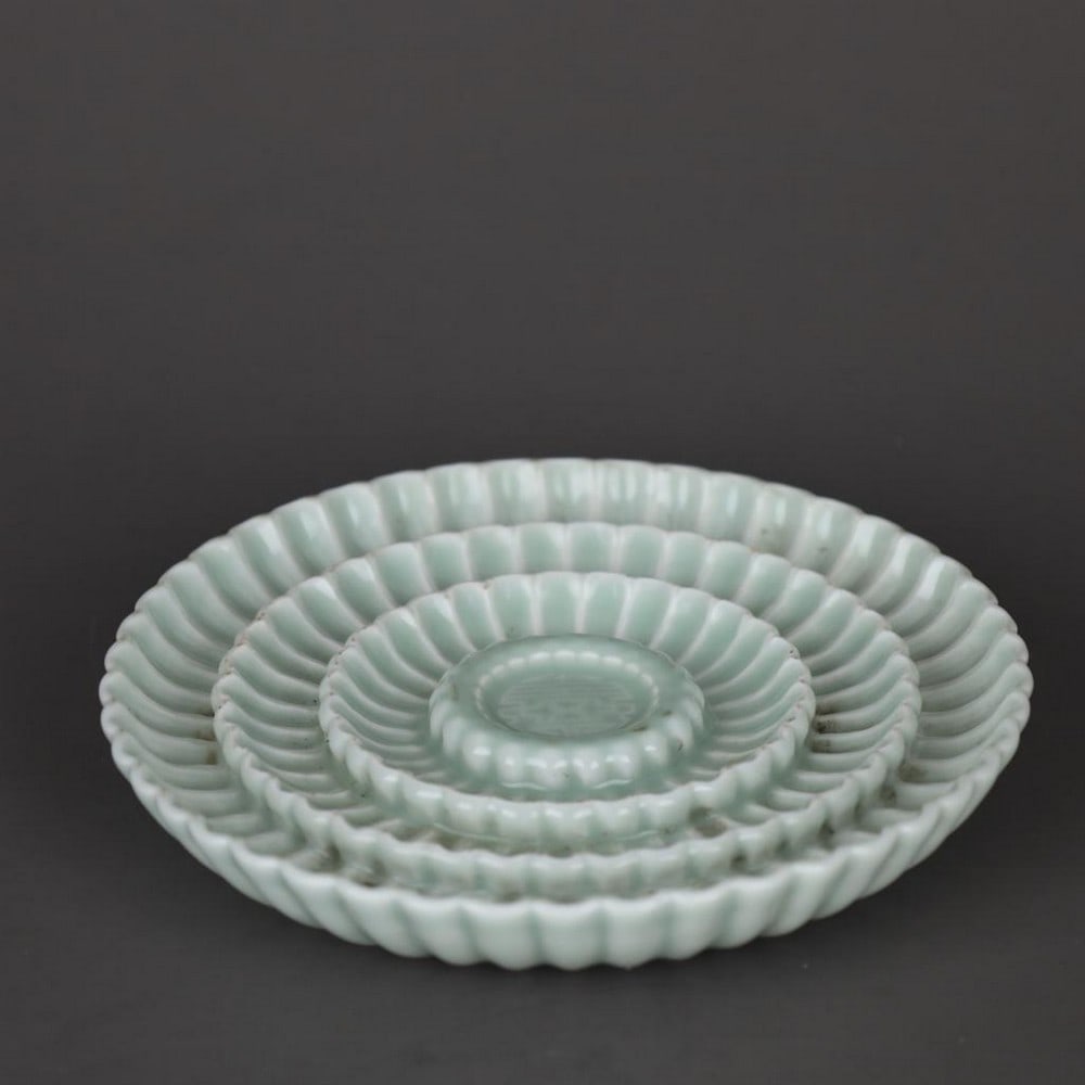 Qing Dynasty Yongzheng Celadon Chrysanthemum Petal Longevity Plate: Qing Dynasty Yongzheng Celadon Chrysanthemum Petal Longevity Plate A finely crafted celadon porcelain plate from the Yongzheng period of the Qing Dynasty. The surface is delicately molded with chrysan