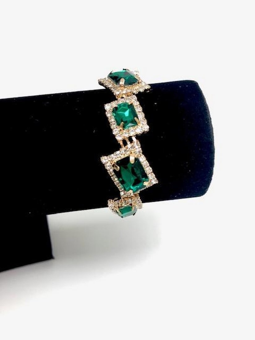 Green Gemstone Gold-Tone Bracelet: Green Gemstone Gold-Tone Bracelet This elegant bracelet features a series of large rectangular green stones, each framed by sparkling white crystals and set in gold-toned metal. The combination of