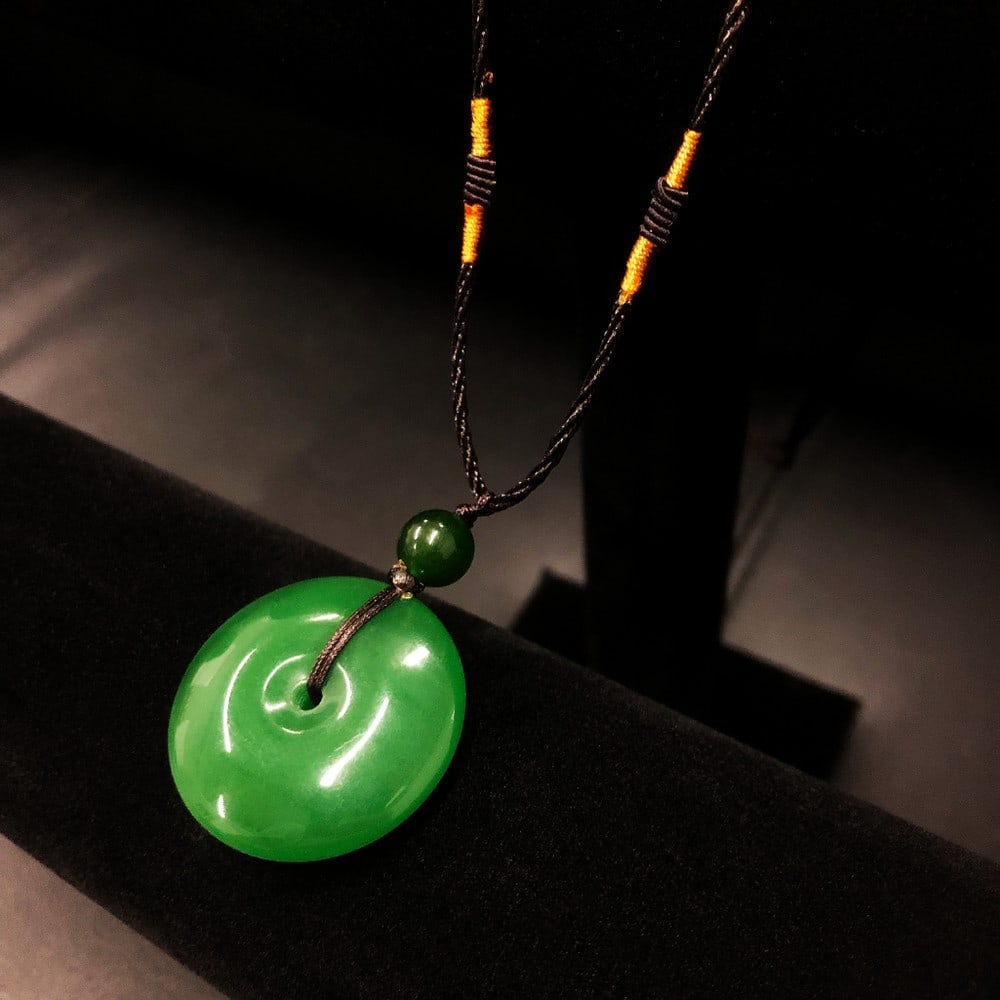 Green Jade Pendant Necklace on Rope Cord: Green Jade Pendant Necklace on Rope Cord This elegant necklace features a natural green jade pendant suspended from a durable rope cord, offering a casual yet refined look. The smooth, vibrant