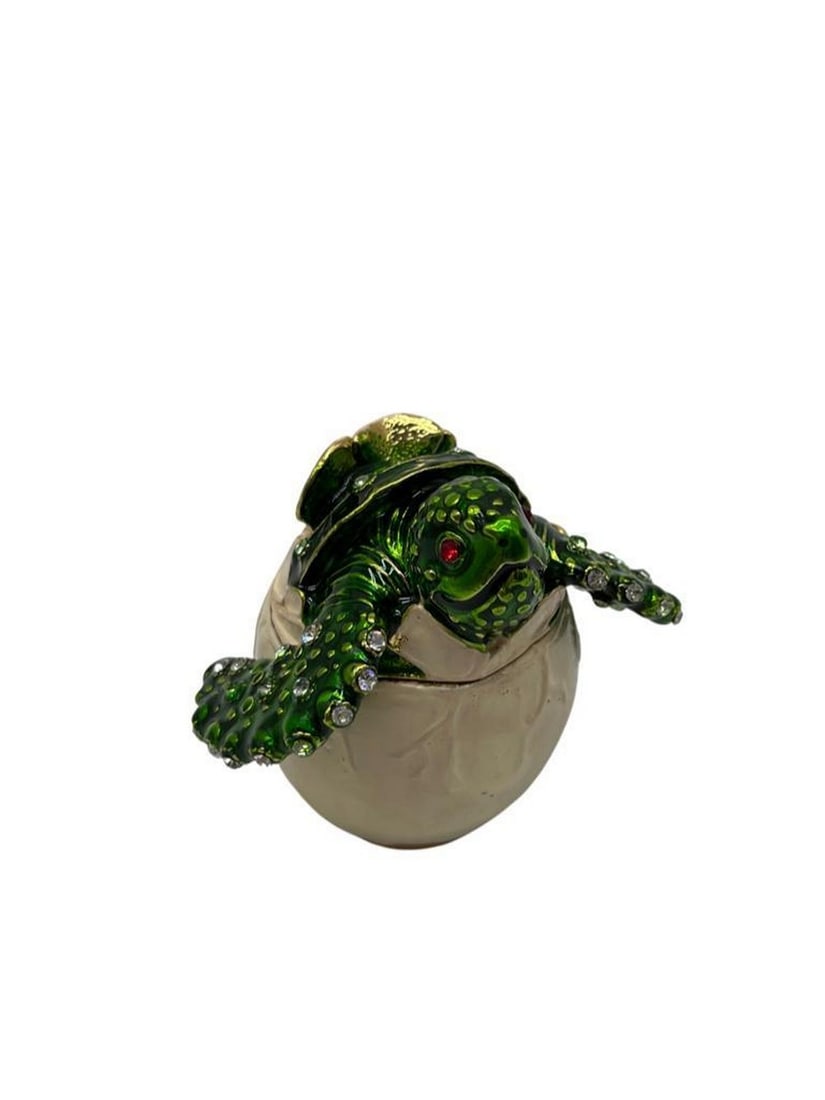 Hatching Turtle Trinket Box: Hatching Turtle Trinket Box This is a unique trinket box that depicts a turtle hatching out of its shell and entering the world. It is an enameled trinket box with a magnetic closing latch. The trink