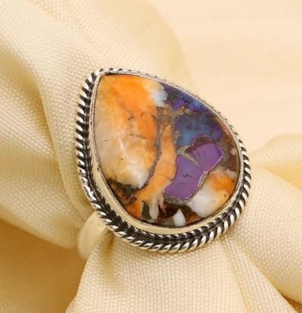 Vivid Harmony: Vivid Harmony — Purple & Copper Oyster Teardrop Ring Immerse yourself in the captivating beauty of this exquisite ring, a true testament to nature's artistry and skilled craftsmanship.
