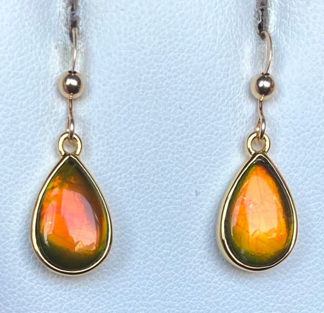 Teardrop Orange Ammolite Earrings: Teardrop Orange Ammolite Earrings These teardrop-shaped Ammolite earrings feature 12mm x 8mm low-dome quartz-capped triplets. Set in gold-plated (vermeil) sterling silver, they hang from gold-filled