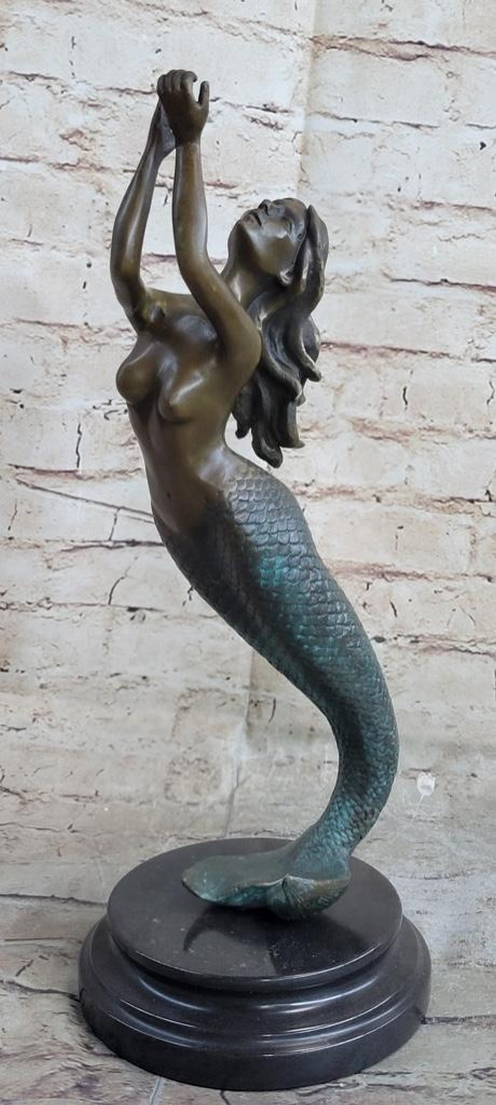 Nude Mermaid Bronze Sculpture: Nude Mermaid Bronze Sculpture The beautiful mermaid can be imagined, holding herself up with her fishtail, among the ocean`s body of her water kingdom. Her arms are raised and cupped