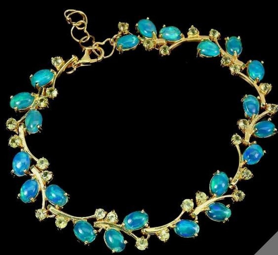 Blue Opal & Peridot Gemstone Bracelet: Blue Opal & Peridot Gemstone Bracelet This elegant 925 sterling silver bracelet features luminous oval blue opal gemstones measuring 6×4mm, beautifully accented with vibrant green peridot for