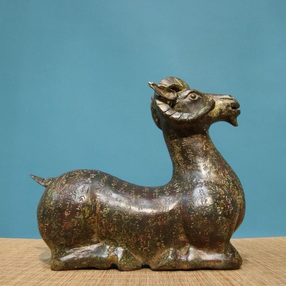 Antique Chinese Bronze Inscribed Lying Sheep Statue Ornament: Antique Chinese Bronze Inscribed Lying Sheep Statue Ornament This rare handcrafted bronze statue depicts a serene lying sheep adorned with intricate inscriptions, symbolizing peace and prosperity in C