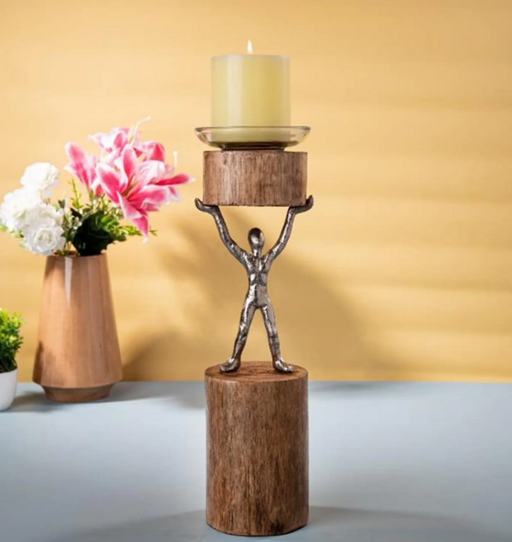 Aluminum and Wood Candle Stand Featuring Man Figure – 15": Aluminum and Wood Candle Stand Featuring Man Figure – 15" A 15.2-inch candle stand combining aluminum and wood, depicting a man holding a candle. The piece reflects themes of contemplation and
