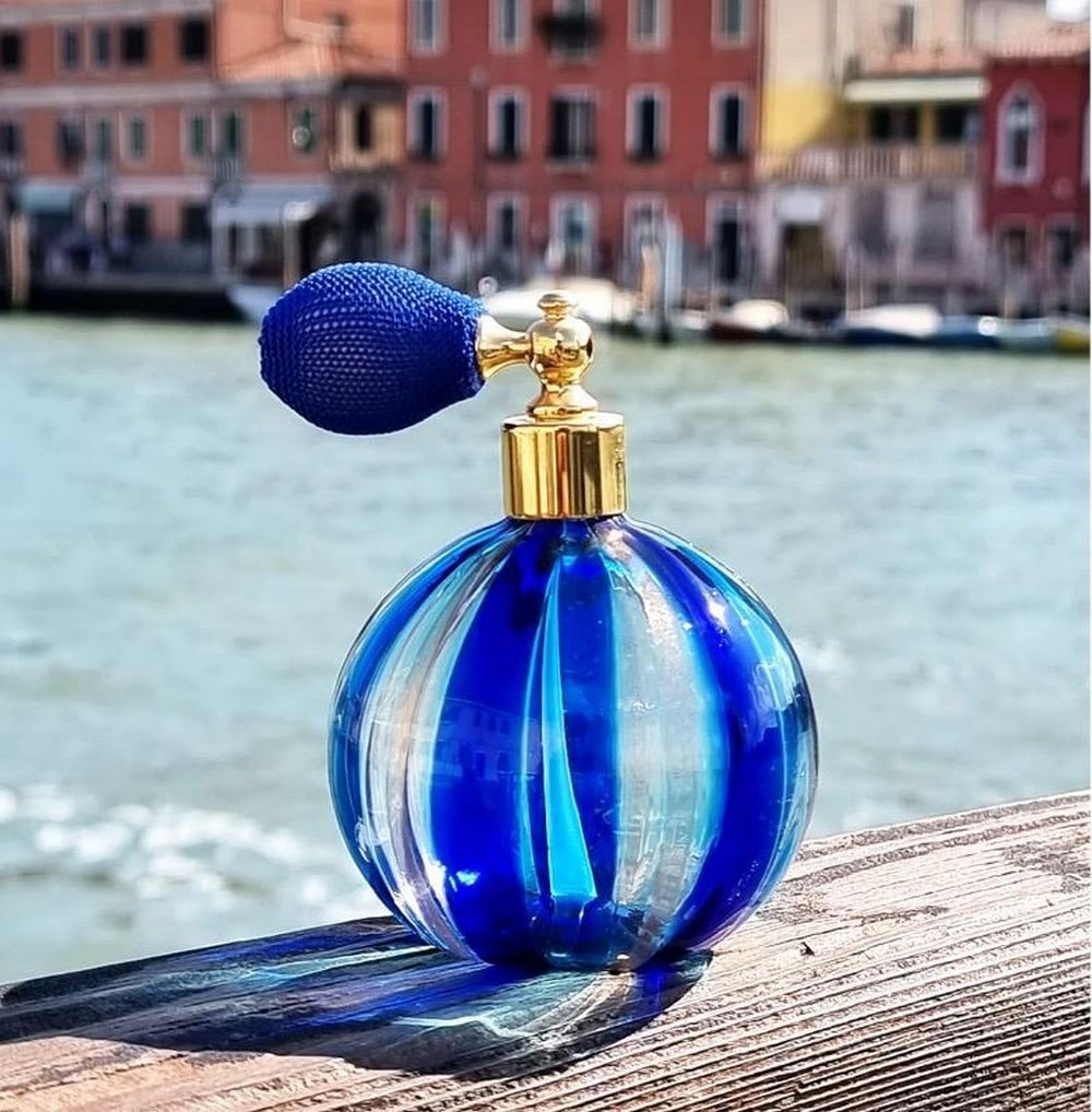 Blue Aventurine Murano Glass Perfume Atomizer Bottle: Blue Aventurine Murano Glass Perfume Atomizer Bottle Introducing our Little Blue Bottle, a captivating creation meticulously crafted with the artful technique of blown glass and adorned with mesmeriz