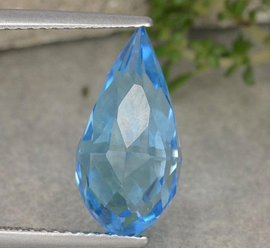 6.65 ct Briolette Swiss Blue Topaz Gemstone: 6.65 ct Briolette Swiss Blue Topaz Gemstone Introducing the Briolette Swiss Blue Topaz Gemstone, a vivid teardrop gem with a carefully faceted briolette cut that highlights its clarity and rich blue c