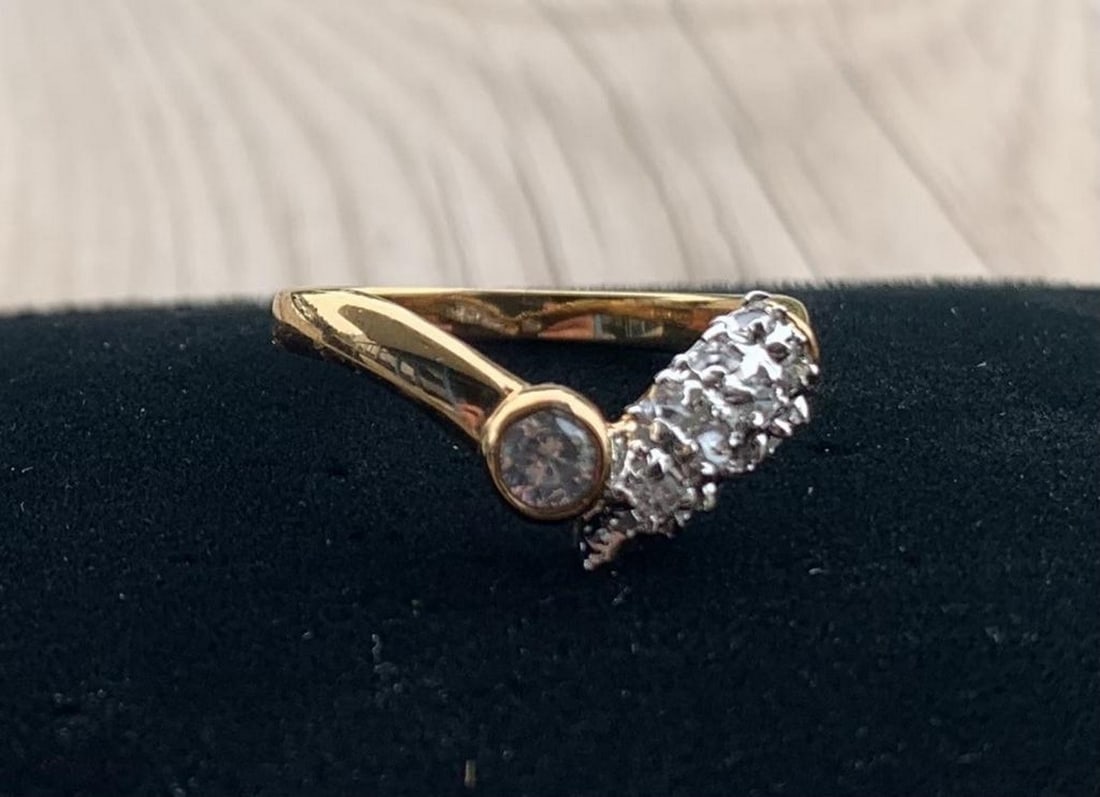 Golden Grace CZ Split Band Ring: Golden Grace CZ Split Band Ring An exquisite display of elegance and modern design, this gold ring features a distinctive split band—one side cradling a bezel-set round cubic zirconia, the other ad