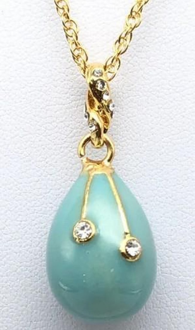 Turquoise Radiance Egg Pendant Necklace: Turquoise Radiance Egg Pendant Necklace This stunning egg pendant necklace combines the vibrant hues of turquoise enamel with elegant gold accents for a striking contrast. The smooth, glossy