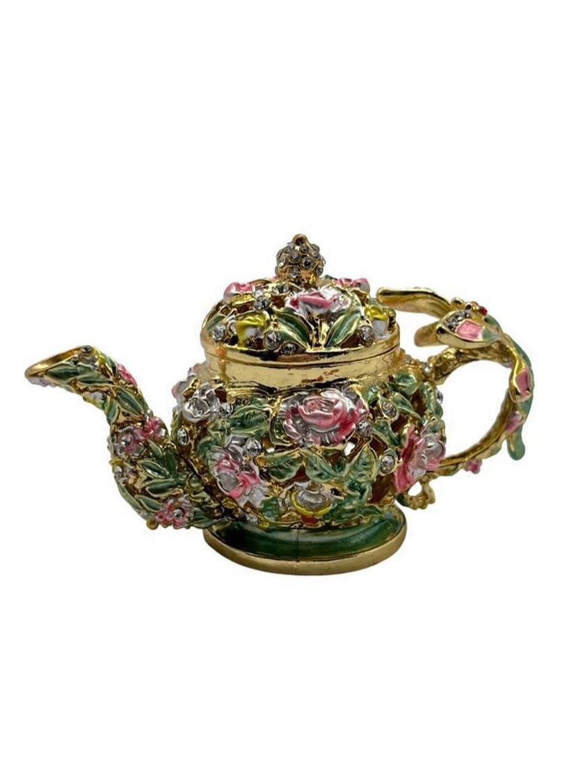 Floral Dragonfly Teapot Trinket Box: Floral Dragonfly Teapot Trinket Box This trinket box is a captivating accessory crafted from high-quality metal. Adorned with intricate floral and dragonfly designs, it features sparkling faux jewels