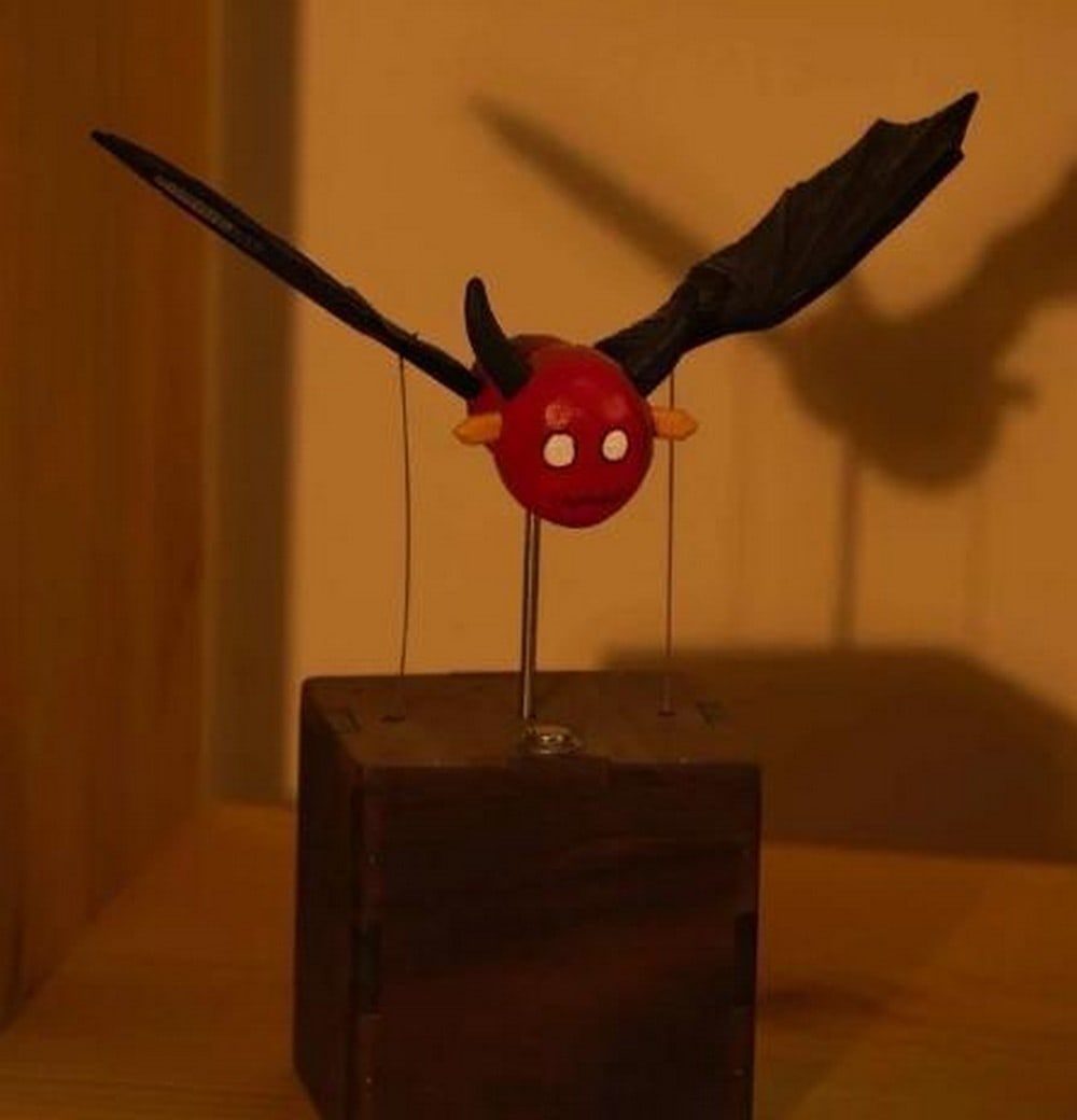 Handcrafted Flying Devil Automaton in Basswood & Walnut: Handcrafted Flying Devil Automaton in Basswood & Walnut Bold and mischievous, this handcrafted automaton features a winged devil in mid-flight, brought to life with rich character and expert craf