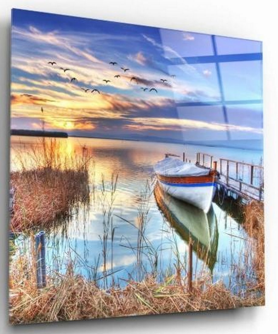 Harbor Serenity Tempered Glass Wall Art: Harbor Serenity Tempered Glass Wall Art This tempered glass wall art captures a peaceful waterfront moment, where a lone boat rests gently beside a weathered dock. In the foreground, tall yellow gras