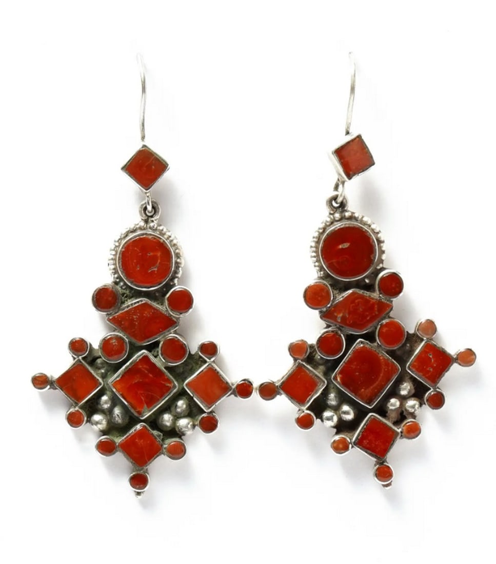 Enchanted Crimson Coral Earrings: Enchanted Crimson Coral Earrings These Coral Hook Earrings showcase vibrant red coral, revered for its rich color and historical significance. Framed in sterling silver with a slightly rugged
