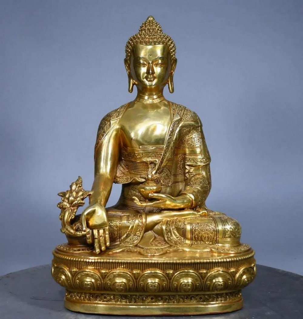 Gilded Copper Medicine Buddha Statue: Gilded Copper Medicine Buddha Statue This exquisite antique statue of the Medicine Buddha embodies healing and compassion, crafted from rare pure copper with a rich gilt finish. Meticulously detailed,