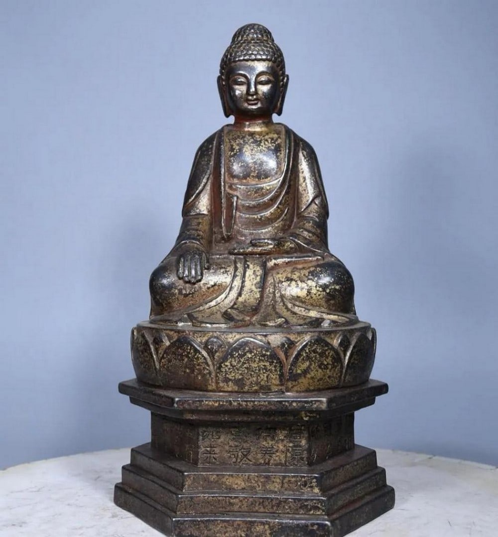 Cinnabar Painted Copper Sakyamuni Buddha Statue: Cinnabar Painted Copper Sakyamuni Buddha Statue This rare statue of Sakyamuni Buddha is a masterpiece of traditional craftsmanship, featuring pure copper adorned with rich cinnabar painting. With sere