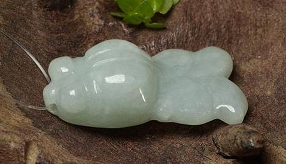 Grey Green Jadeite Carved Fish Gemstone with Piercing: Grey Green Jadeite Carved Fish Gemstone with Piercing Crafted from natural jadeite in a serene grey-green hue, this loose gemstone is intricately carved into the form of a graceful fish. A small