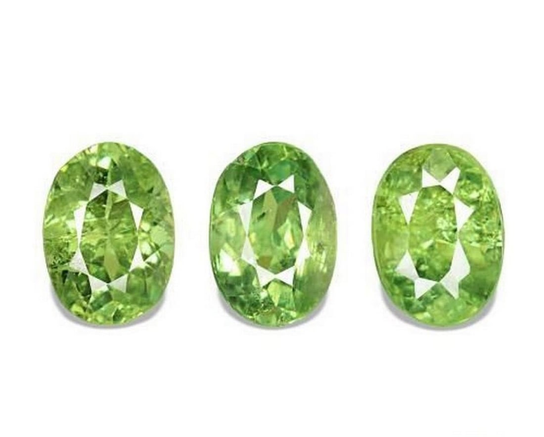 2.08 ct Natural Warm Green Demantoid Garnet, Oval Facet, VS–SI, Namibia: 2.08 ct Natural Warm Green Demantoid Garnet, Oval Facet, VS–SI, Namibia Natural demantoid garnet totaling 2.08 carats, consisting of three oval-cut faceted gemstones with a rich warm green color.