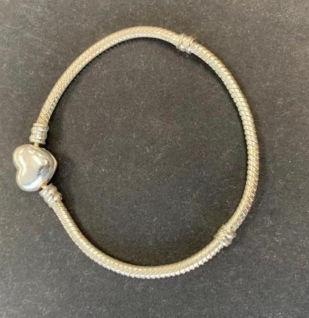 Silver-Toned Bracelet with Heart Clasp: Silver-Toned Bracelet with Heart Clasp This silver-toned bracelet features a charming heart-shaped clasp that adds a touch of sweetness to its classic design. Lightweight and stylish, it’s