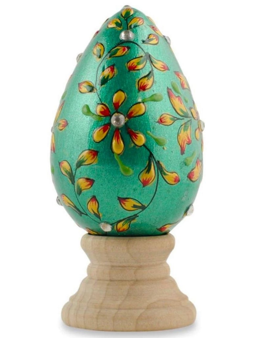 Jewelled Gorgeous Green Flowered Wooden Easter Egg: Jewelled Gorgeous Green Flowered Wooden Easter Egg This green wooden egg is decorated with red and yellow leaves and flowers. The egg is 3 inches tall and 1.75 inches in diameter. It comes with a sta