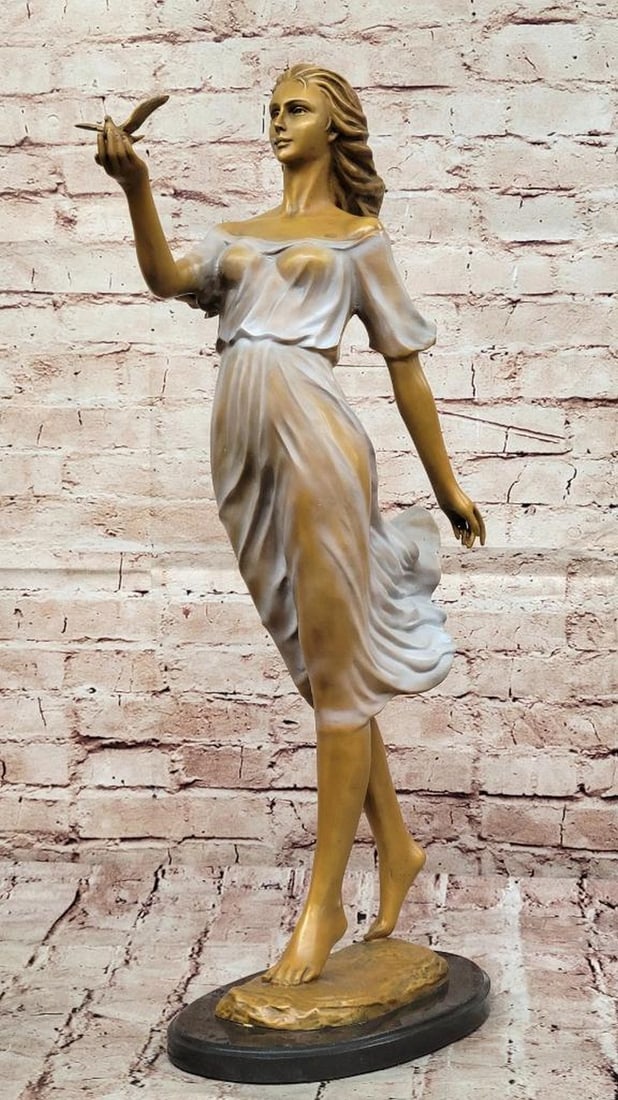 Graceful Lady with Bird Bronze Sculpture - 24" x 11": Graceful Lady with Bird Bronze Sculpture - 24" x 11" This elegant bronze sculpture portrays a woman gently holding a bird, symbolizing freedom and harmony with nature. Crafted using traditiona
