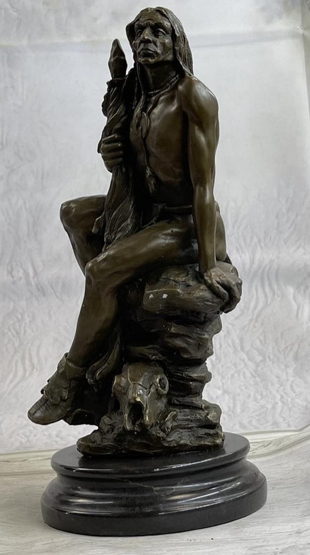 Original Native American Warrior Bronze Sculpture: Original Native American Warrior Bronze Sculpture A Native American warrior sits on a rugged stone. He grasps his hand-carved spear firmly in his hand. As he leans and rests on his hand h