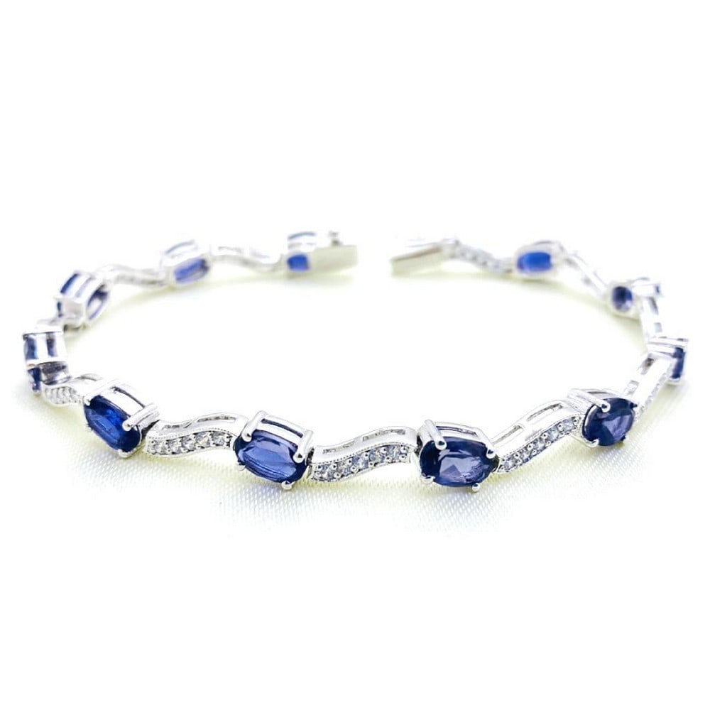 Iolite and Zirconia Studded Wave Bracelet: Iolite and Zirconia Studded Wave Bracelet This stunning bracelet features blue iolite stones with zirconia stones inbetween. View Photos For Further Details.