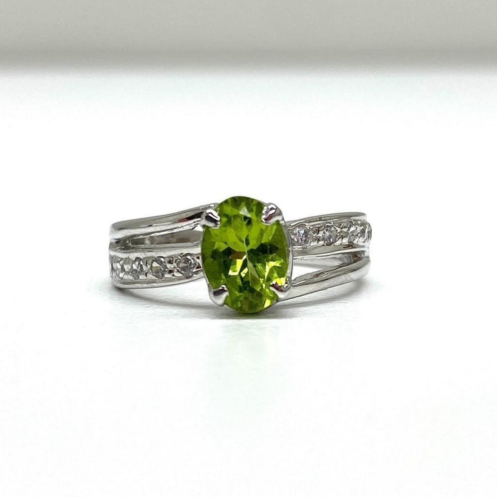 925 Sterling Silver Ring with Austrian Crystal Double Band and a Peridot Gemstone in a Halo Setting: 925 Sterling Silver Ring with Austrian Crystal Double Band and a Peridot Gemstone in a Halo Setting. Peridot gemstones are associated with harmony, peacefulness, good health, and restful sleep. This
