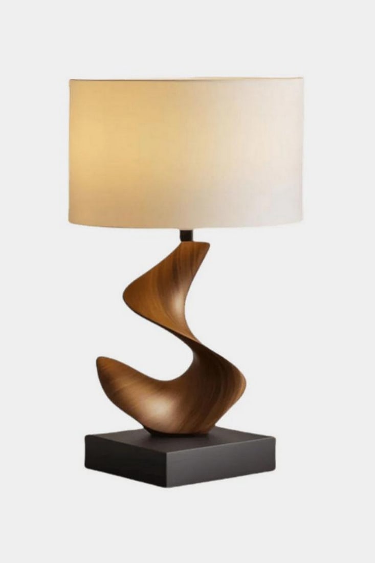 Abstract Ribbon-Form Table Lamp: Abstract Ribbon-Form Table Lamp Elegant and expressive, this handcrafted table lamp features a sculptural wooden base shaped like a flowing ribbon or wave. Resting on a sleek black platform, the dynam