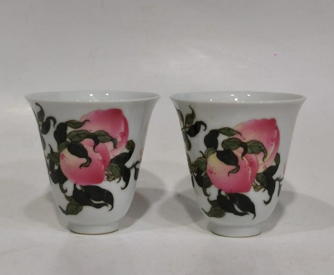 Qianlong Year of the Qing Dynasty Famille Rose Peach Cups, Pair: Qianlong Year of the Qing Dynasty Famille Rose Peach Cups, Pair A fine pair of famille rose porcelain cups from the Qianlong period of the Qing Dynasty. Each cup is delicately decorated with peaches,