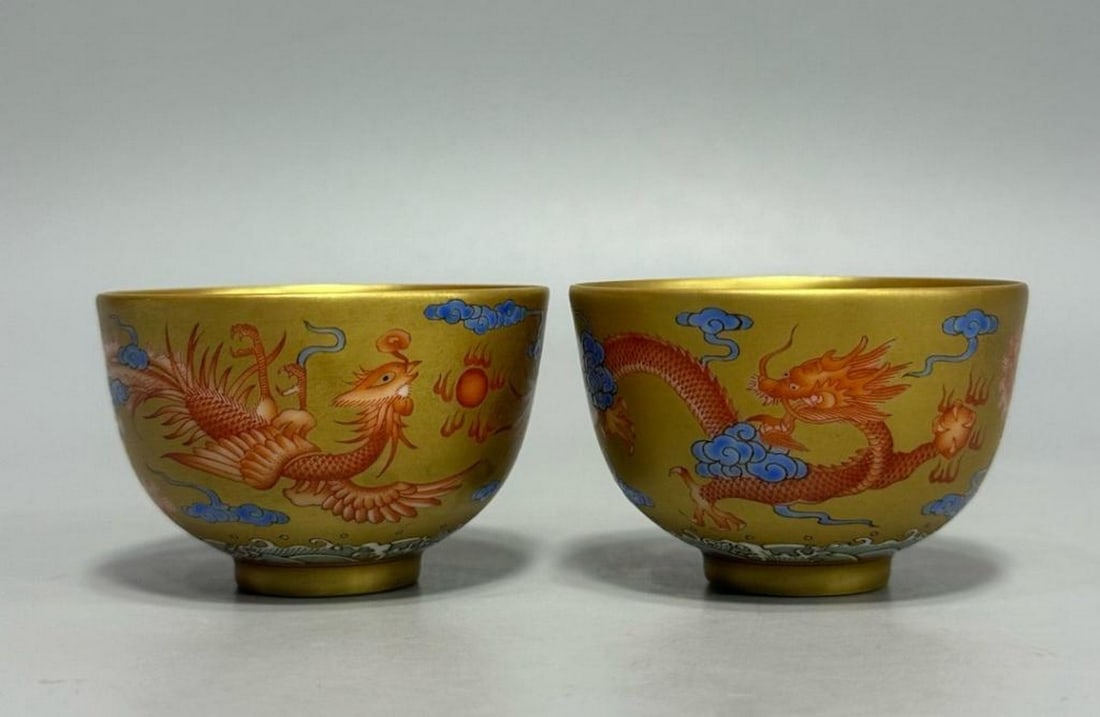 Yongzheng Year of the Qing Dynasty Famille Rose Landscape Pattern Cups, Pair: Kangxi Era of the Qing Dynasty Golden Land Dragon and Phoenix Cup A finely crafted porcelain cup from the Kangxi period of the Qing Dynasty, decorated with a dynamic dragon and phoenix motif in gold o