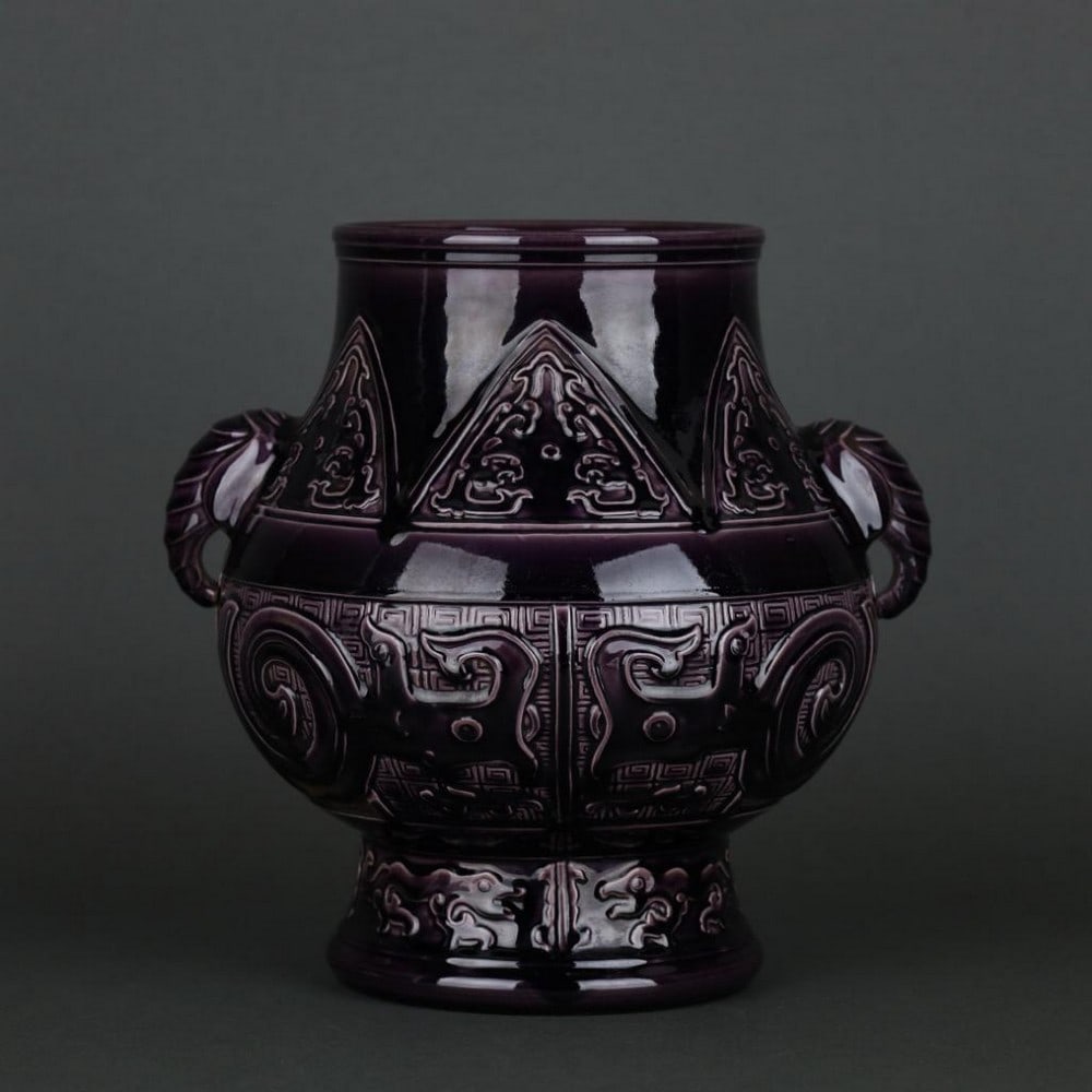 Qing Dynasty Qianlong Eggplant-Purple Glaze Carved Gluttonous Pattern Elephant-Ear Vase: Qing Dynasty Qianlong Eggplant-Purple Glaze Carved Gluttonous Pattern Elephant-Ear Vase A rare and finely crafted elephant-ear vase from the Qianlong period of the Qing Dynasty, finished in the distin