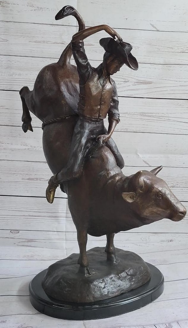 Inspired Rodeo Bull Rider Bronze Sculpture - 24" x 19": Inspired Rodeo Bull Rider Bronze Sculpture - 24" x 19" A seasoned cowboy courageously rides a bucking bull in the center of the rodeo. The bull leaps, kicks and twist, raising the cowboy high