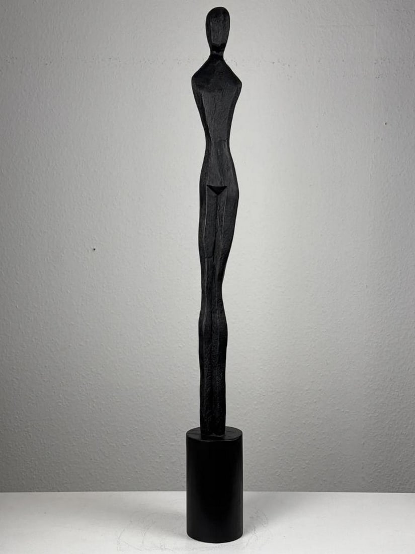Slim Minimalist Female Sculpture in Black: Slim Minimalist Female Sculpture in Black A sleek and contemporary abstract female figure, crafted with clean lines and finished in a deep black tone. Designed for modern interiors, it makes a striki