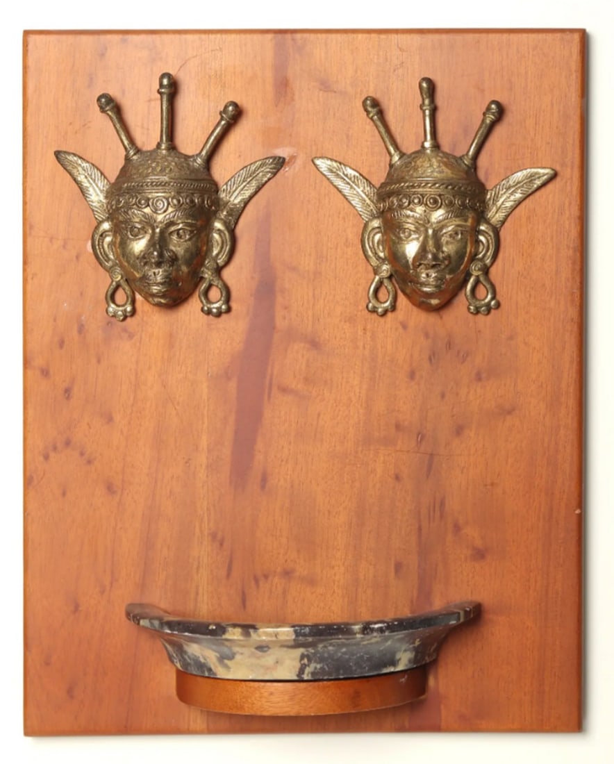 Dhokra Art Candle Holder with Tribal Figurine – Wall Hanging: Dhokra Art Candle Holder with Tribal Figurine – Wall Hanging A 10-inch brass and wood candle holder designed as a wall hanging featuring a tribal figurine. Crafted using traditional Dhokra metal ca