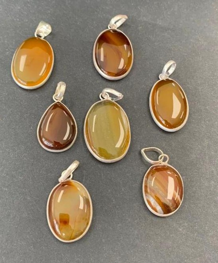 Lot of 7 Sterling Silver Agate Oval Pendants: Lot of 7 Sterling Silver Agate Oval Pendants This beautiful lot includes seven natural agate pendants, each set in sterling silver. While all pendants feature an oval-inspired shape, each piece