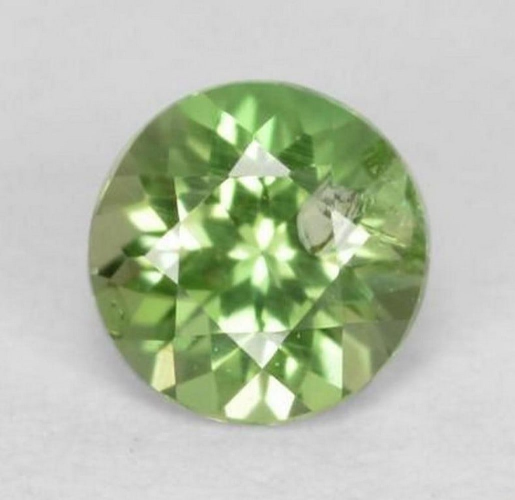 0.21 ct Natural Bright Green Kornerupine, Round Cut, SI, Sri Lanka: 0.21 ct Natural Bright Green Kornerupine, Round Cut, SI, Sri Lanka Natural kornerupine gemstone weighing 0.21 carats, cut in a round facet shape with a bright green color. The gem measures 3.76 x