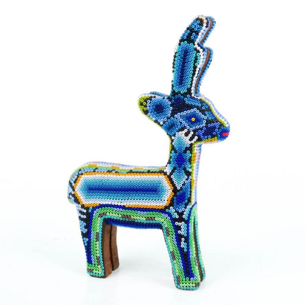 Huichol Beaded Blue Deer Sculpture: Huichol Beaded Blue Deer Sculpture Exquisite handcrafted by the indigenous Huichol community of Jalisco, this magnificent beaded deer showcases their exceptional artistry. Crafted from wood, the deer