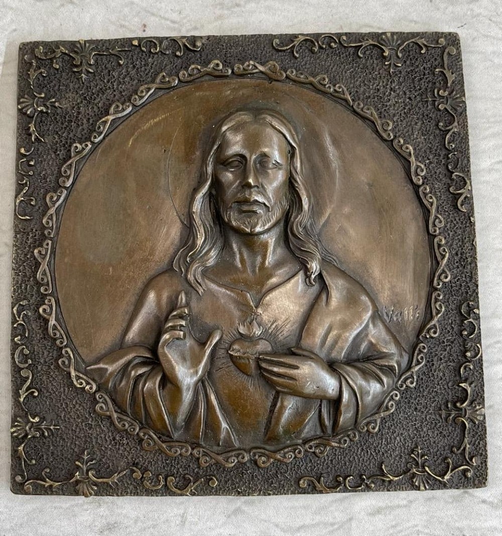 Jesus Christ Wall Mount Original Bronze - 6" x 6": Jesus Christ Mall Mount Original Bronze - 6" x 6" This piece portrays a bronze wall mount depicting Jesus Christ, a central figure in Christianity. The relief shows Christ with one hand raise