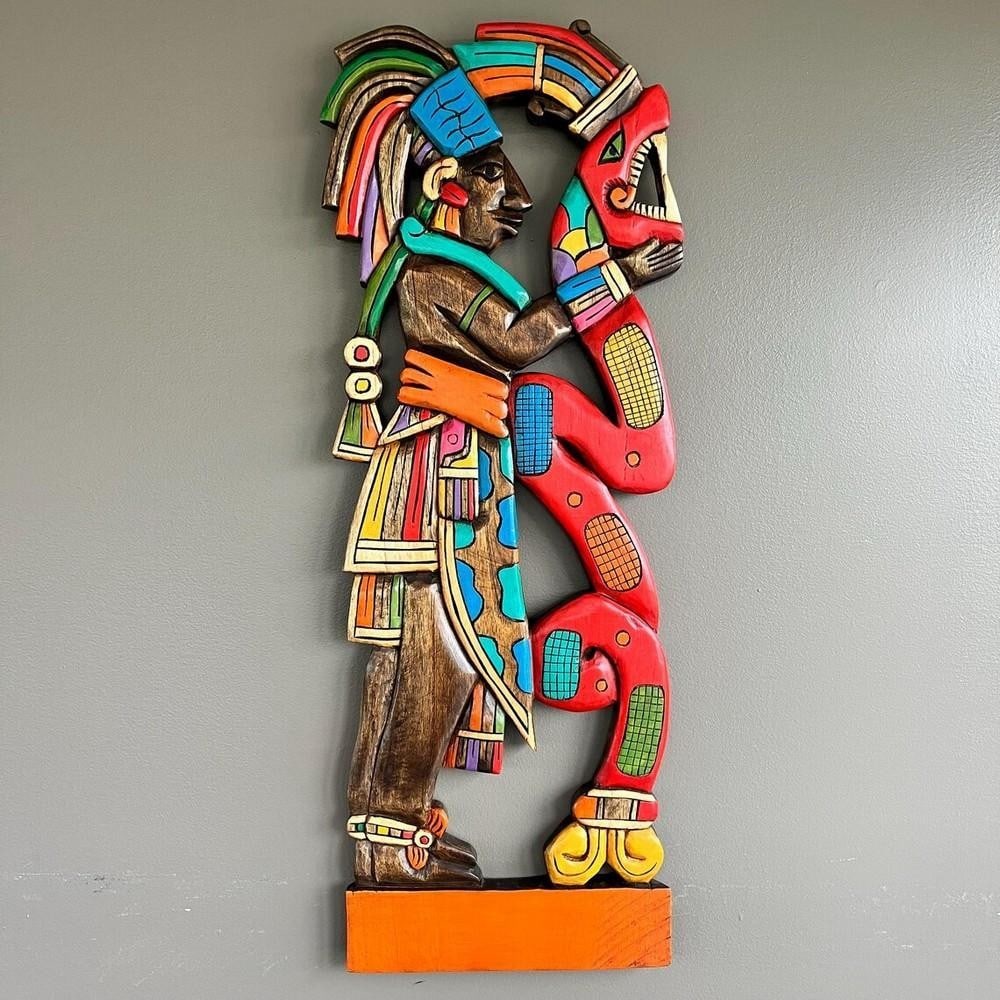 Aztec-Mayan Wooden Mask with Serpent: Aztec-Mayan Wooden Mask with Serpent Hand-carved from rich cedar wood, this striking wall art blends Aztec and Mayan heritage in a captivating 3D design. Depicting Chambalu, the son of the revered May
