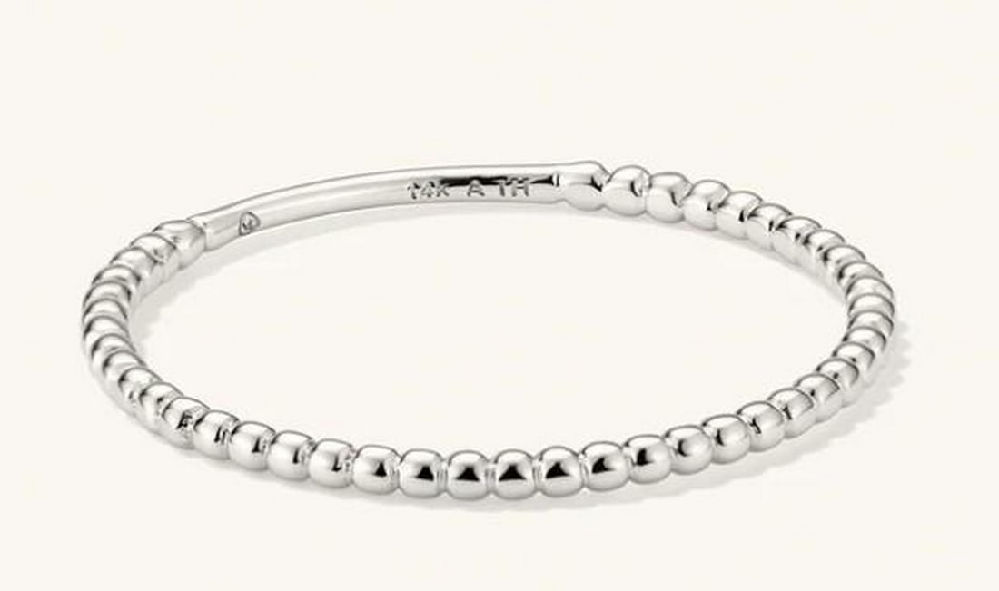 Delicate Beaded Stacking Ring: Delicate Beaded Stacking Ring A subtle essential with textural charm, this beaded ring features a continuous band of polished metal spheres that catch the light with every movement. Perfect for