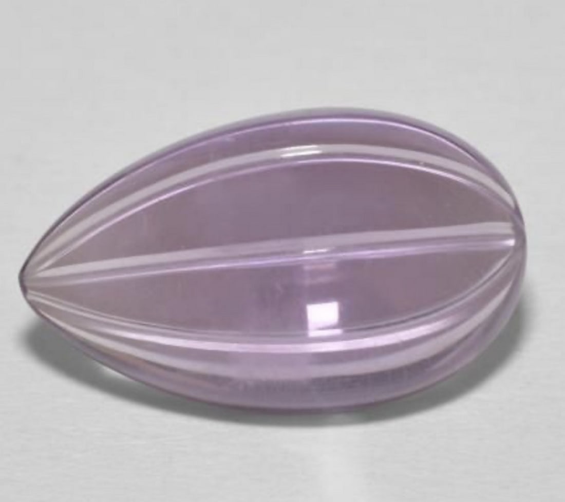 6.10ct Pear Shape Lilac Lust Amethyst: 6.10ct Pear Shape Amethyst Weight: 6.1ct Size: 16.35mm L x 9.8mm W x 5.9mm D Shape: Carved Pear Color: Lilac Clarity: transparent Treatment: Untreated Origin: Brazil View Photos For