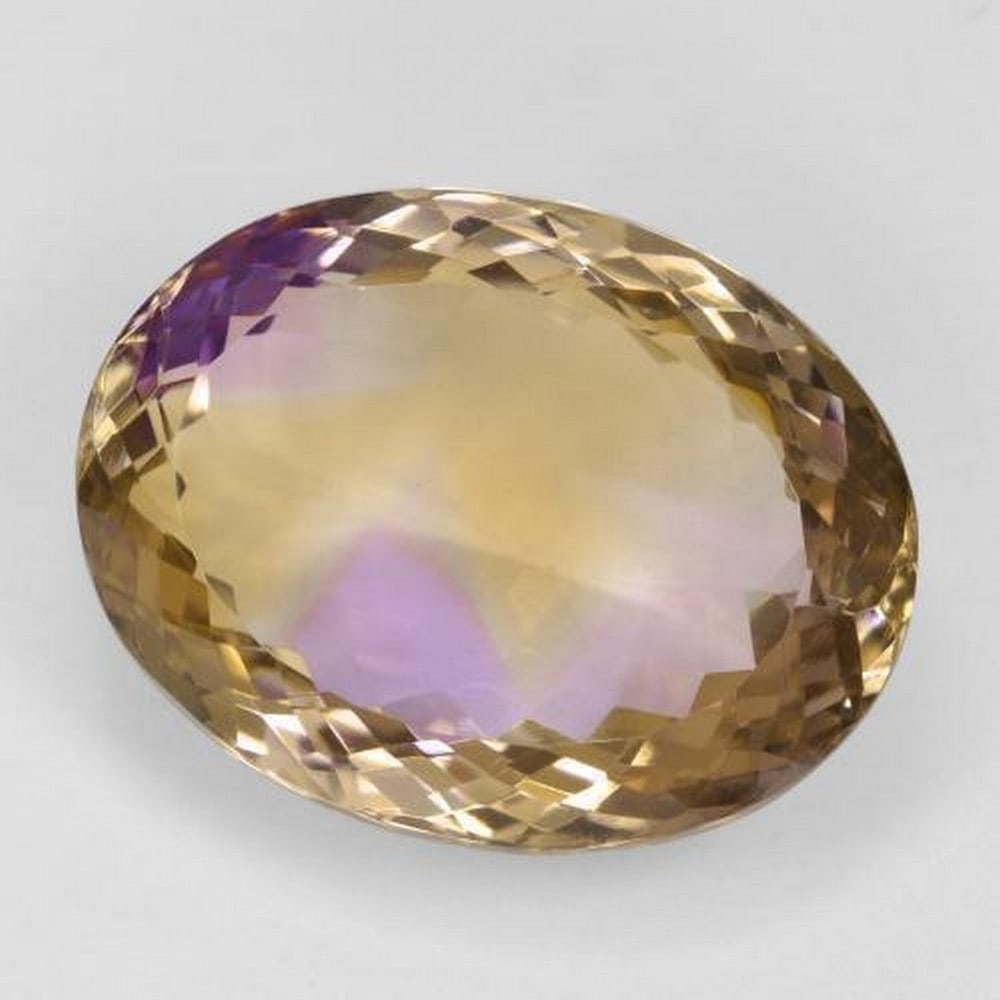 Natural and Rare Oval Bi-color Ametrine Gemstone: Natural and Rare Oval Bi-color Ametrine Gemstone This is a natural and rare bi-color Ametrine in oval facet shape gemstone that measures at 21.65 x 16.57 x 9.93mm. The gemstone was mined in Brazil an