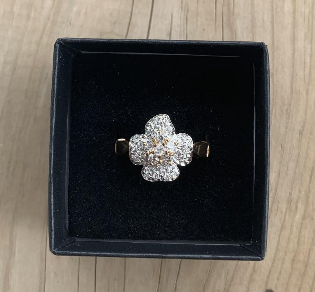 Radiant Floral Moissanite Cluster Ring: Radiant Floral CZ Cluster Ring This breathtaking ring showcases a brilliant cluster of cubic zirconia stones arranged in a graceful floral design, all set atop a gleaming gold band with twin gold