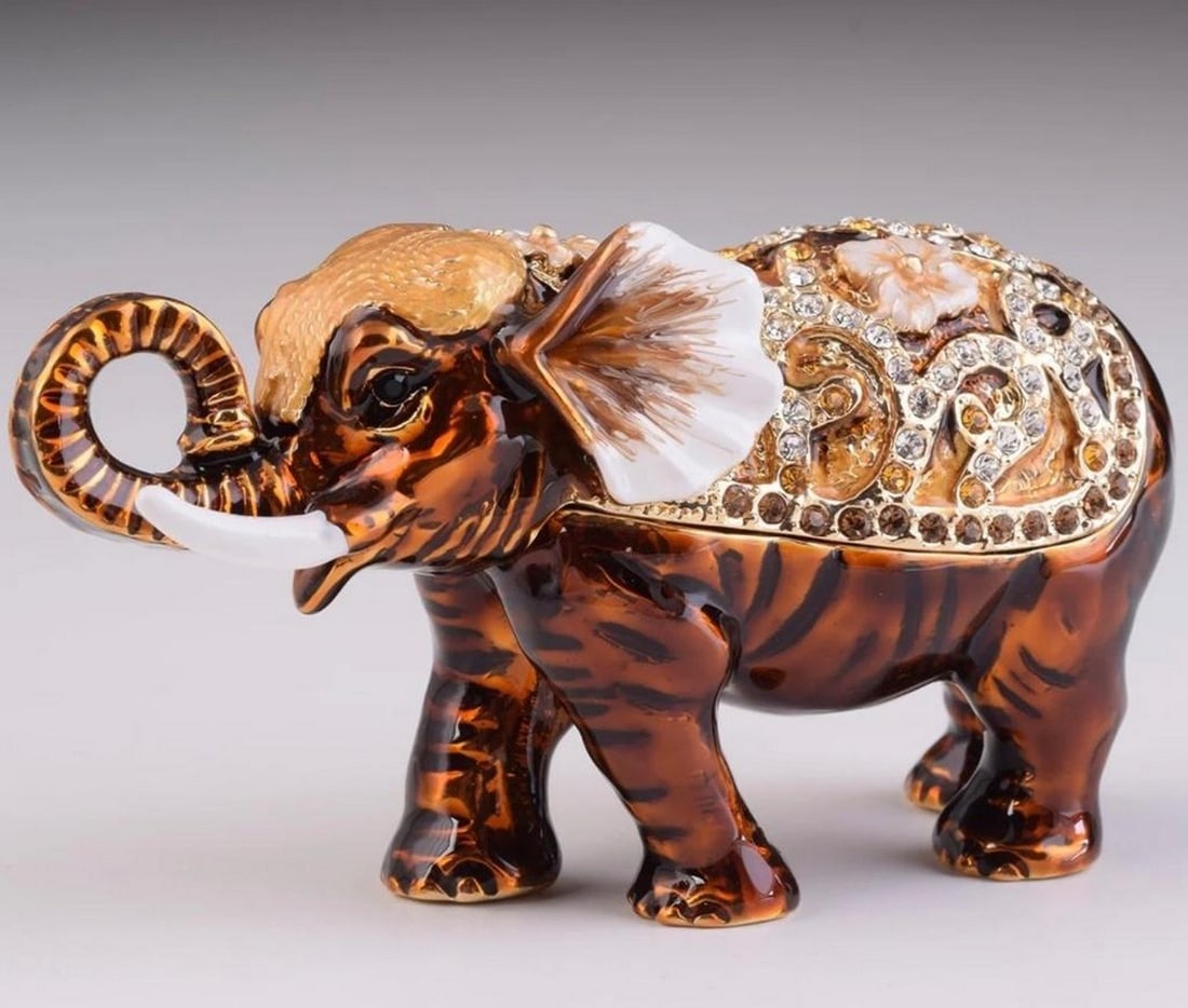 Savannah Sentinel Elephant Trinket Box: Savannah Sentinel Elephant Trinket Box The enchanting design of this trinket box showcases a lifelike brown elephant with intricate detailing that mimics the texture of its majestic hide. On its back