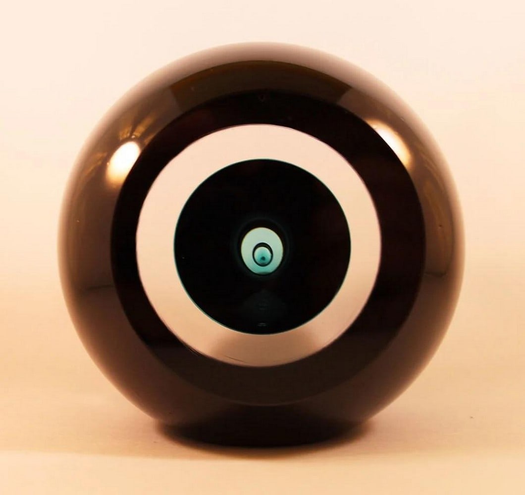 ‘Oculus’ Black Glass Ornament by Remigijus Kriukas: ‘Oculus’ Black Glass Ornament by Remigijus Kriukas Crafted by Lithuanian artist Remigijus Kriukas, the *Oculus* black glass ornament features a sleek, sculptural form with a polished,