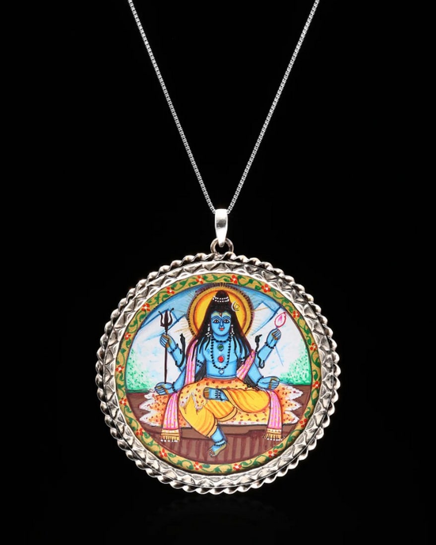 Hand-Painted Mystical Shiva Pendant: Hand-Painted Mystical Shiva Pendant This sterling silver pendant features a hand-painted depiction of Lord Shiva, framed elegantly in a circular design. The detailed miniature painting brings