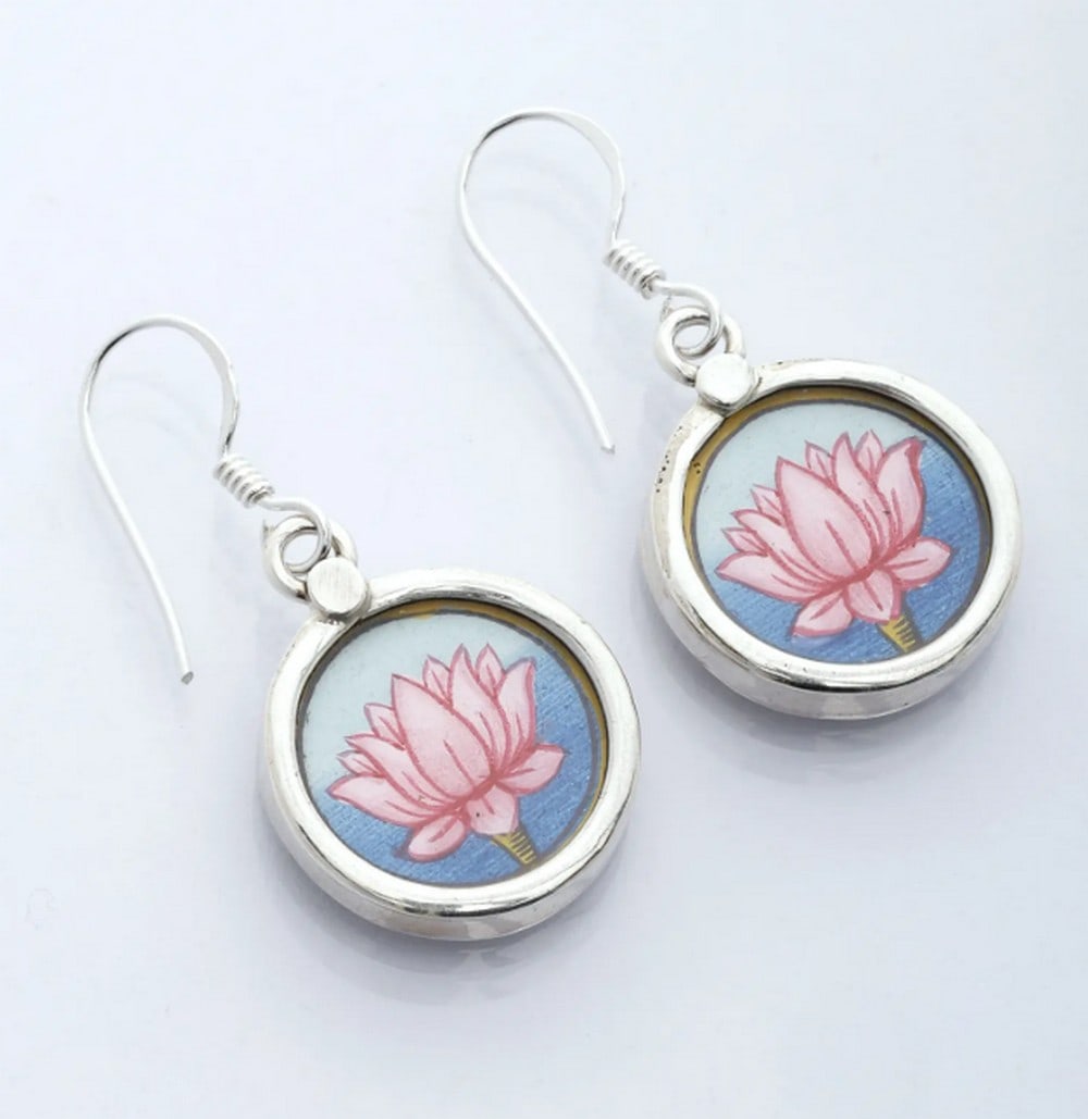 Divine Shrinathji Hook Charms: Divine Shrinathji Hook Charms These sterling silver earrings feature a hand-painted miniature of Shrinathji, capturing India’s rich artistry and heritage. Vibrant colors and intricate details