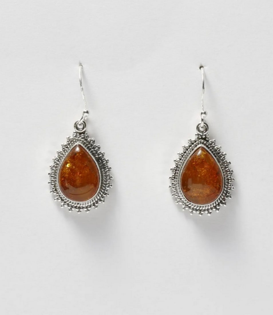Enchanted Golden Amber Dangles: Enchanted Golden Amber Dangles These teardrop-shaped amber earrings exude timeless elegance. Featuring rich, honey-toned cabochons set in delicate sterling silver frames, they blend natural beauty