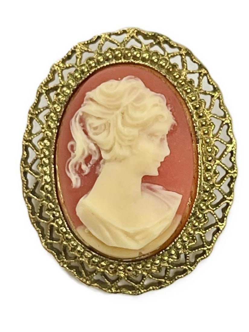 Golden Frame Cameo Brooch with Coral Background: Golden Frame Cameo Brooch with Coral Background Introducing our Golden Frame Cameo Brooch with Coral Background—a harmonious blend of vintage charm and modern sophistication. Encased in a luxurious